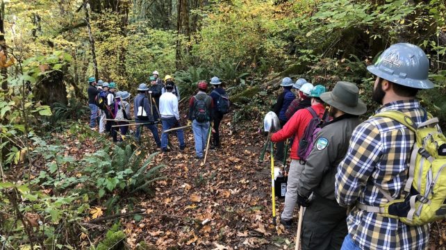 Volunteers listening to trail crew lead describe the work to be done