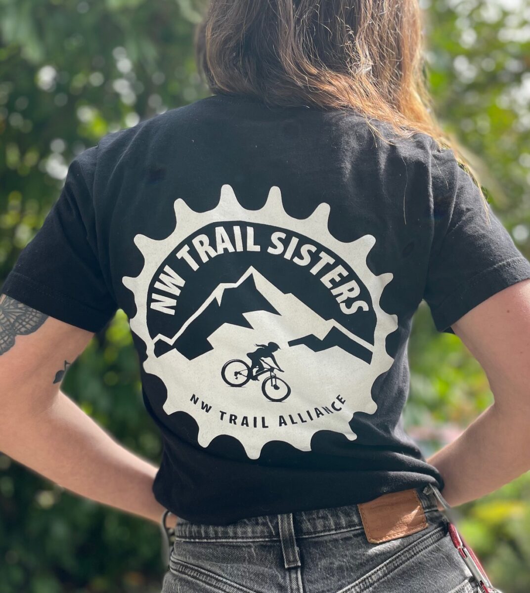 Model wearing Trail Sisters t-shirt that shows the design on the back of the shirt.